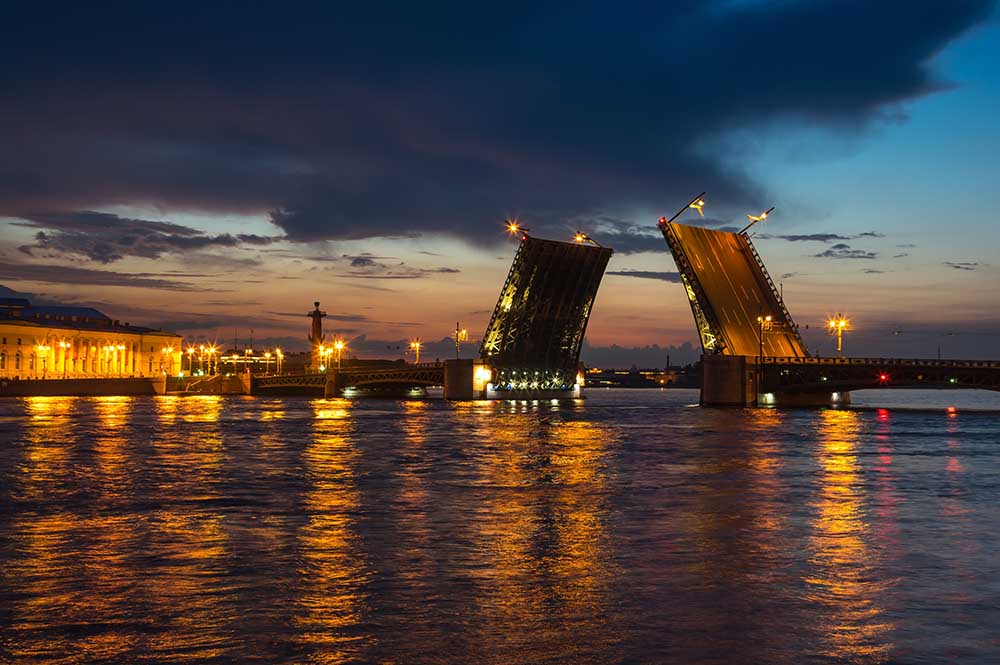 Вечерний вид на Дворцовый мост с набережной Невы в Санкт-Петербурге