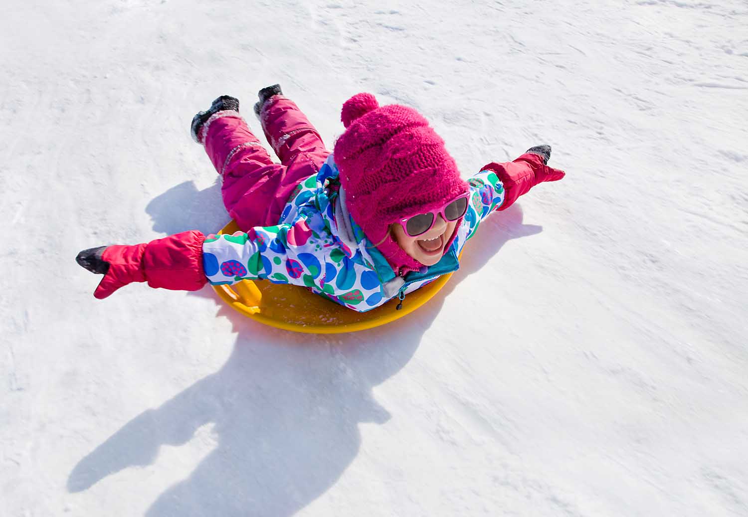 Маленькая девочка катается на снежных горках
