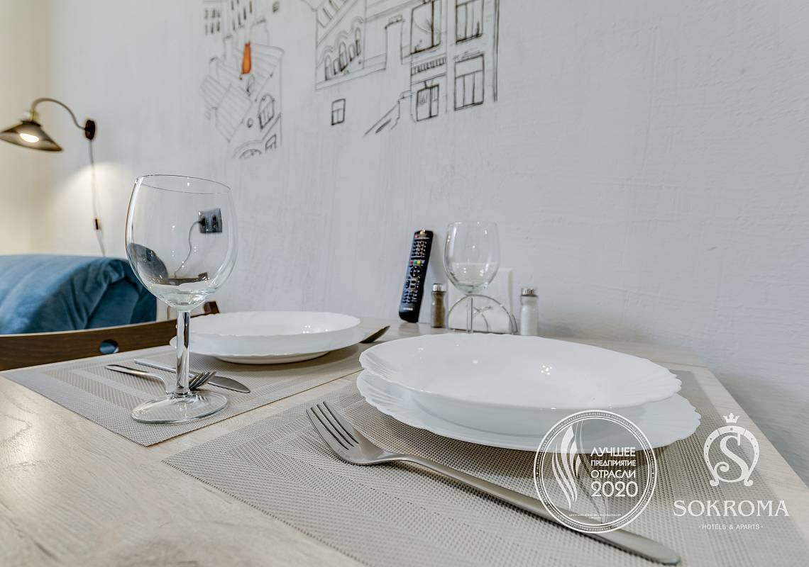 обеденный стол с тарелками и бокалами в апарте