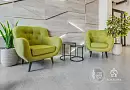 Ярко-зелёные кресла и круглые столики в современном интерьере с растениями и деревянной стеной