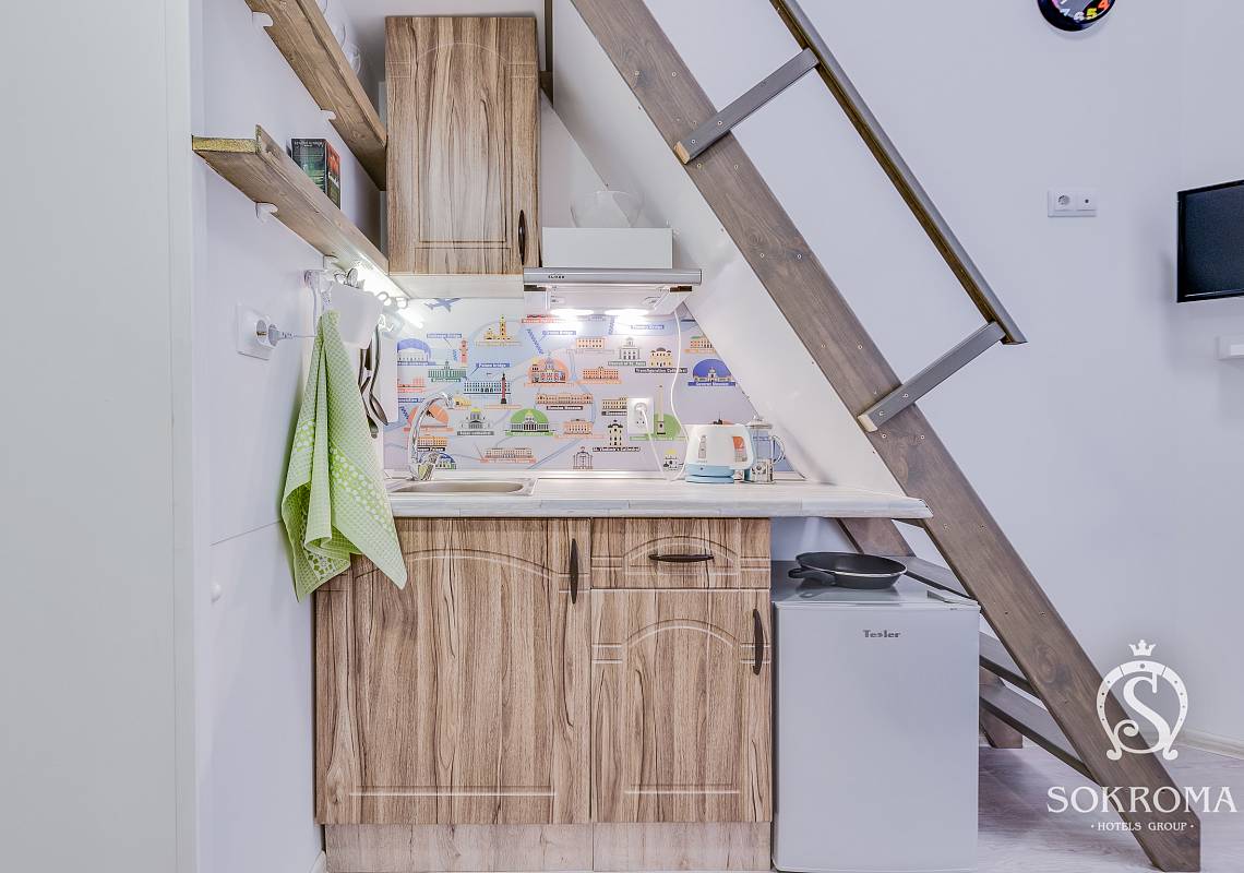 фото кухонного блока под лестницей, обшитой с нижней стороны