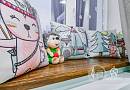 Декоративные подушки с забавными принтами животных и мягкая игрушка ежика на подоконнике.