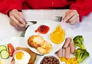 Тарелка с завтраком: сырники, джем, апельсин и сосиски с овощами